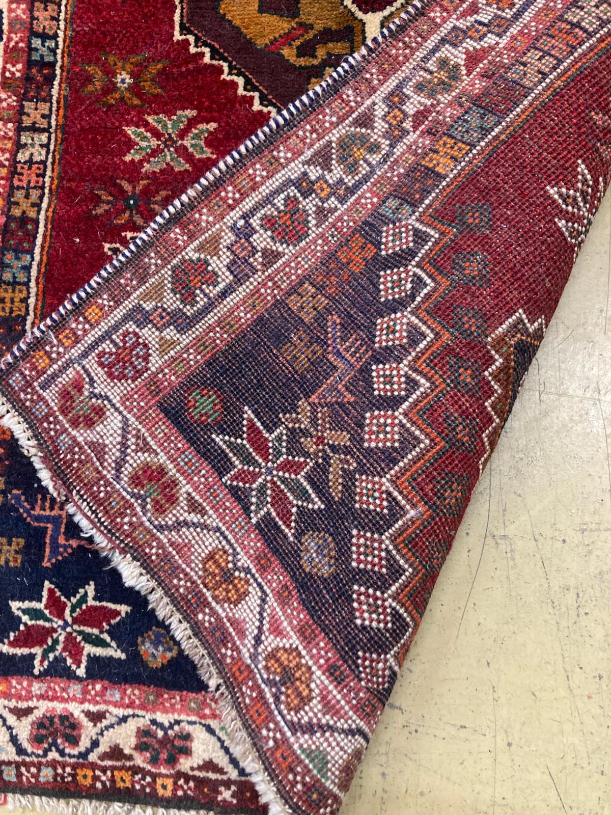 A small Kasak rug with three medallions on a crimson ground, 148 x 95cm